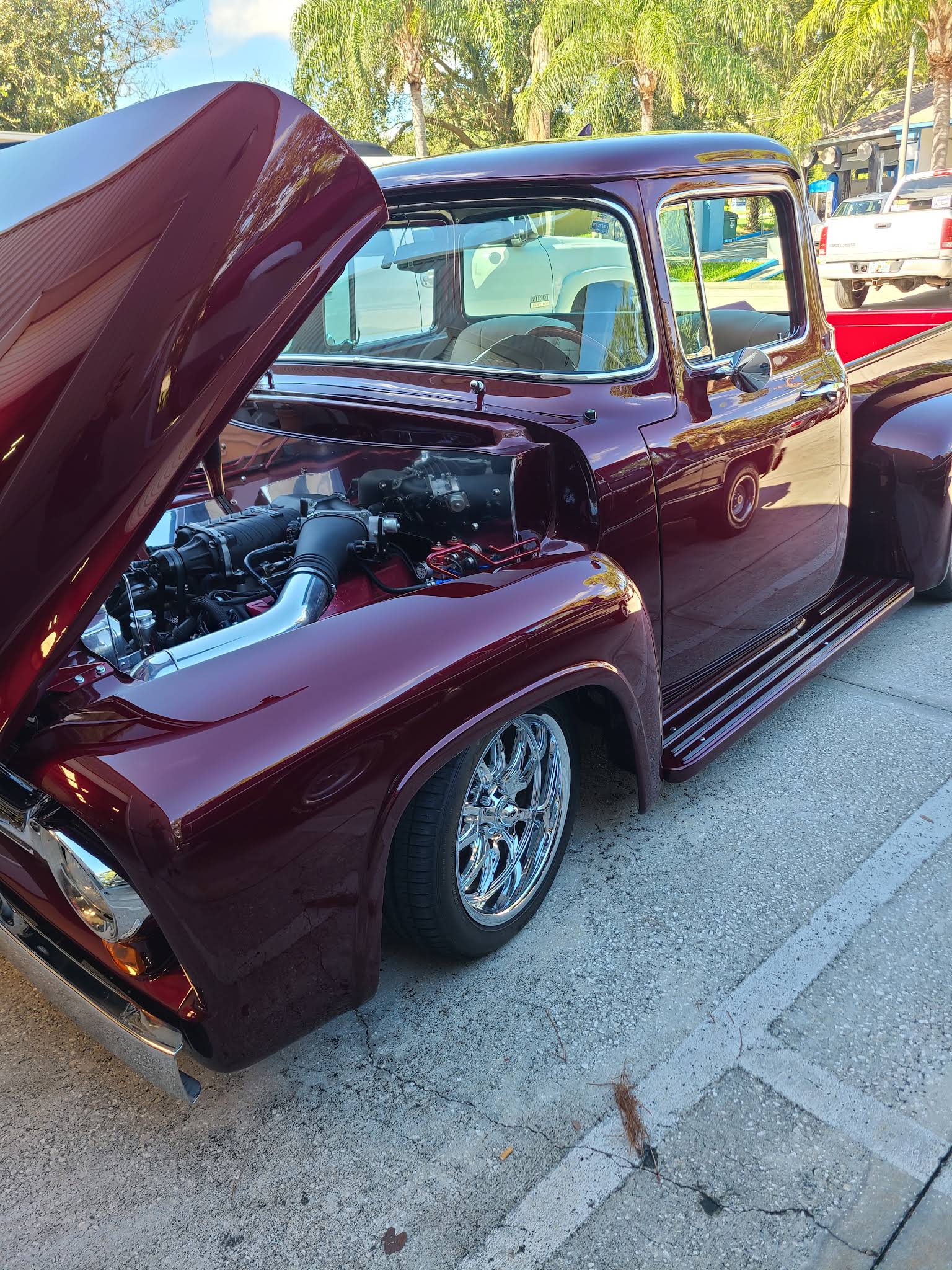 Classic Ford F-100 with hood up showing engine work
